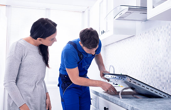 Smart Cover engineer repairing kitchen hobs with customer looking on – Hob Insurance service in action