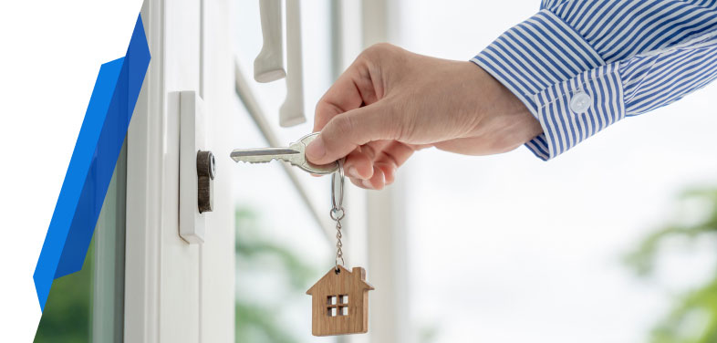 Landlord unlocking property door with house-shaped keychain, symbolising landlord cover and home emergency protection.