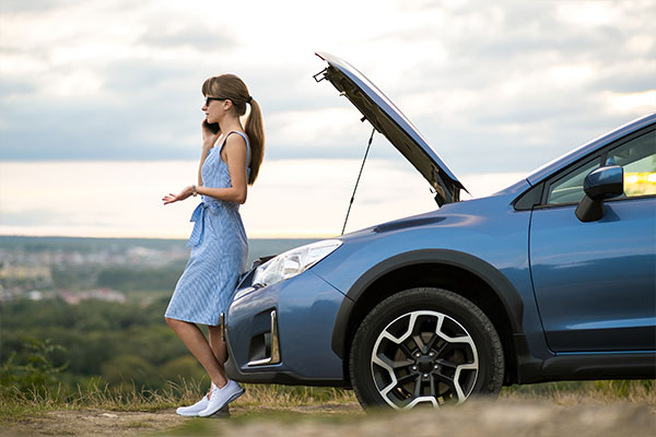Worried woman calling Smart Cover Roadside Assistance for help after a car breakdown.