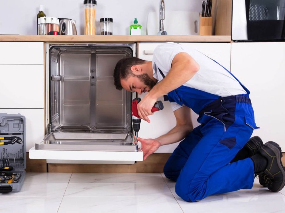 Qualified UK engineer repairing plumbing under a kitchen sink