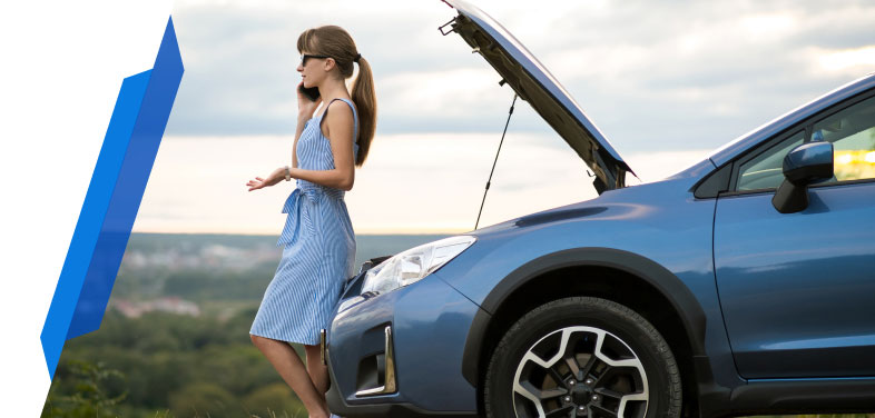 Woman standing in front of broken-down car calling Smart Cover for motor breakdown assistance