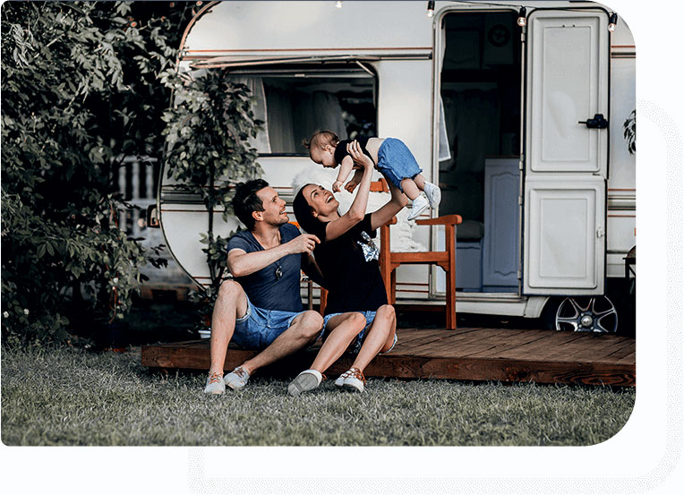 Family sitting and relaxing outside a motorhome with a dog.