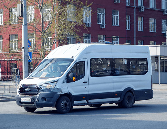Image of a white taxi minibus with a damaged front side