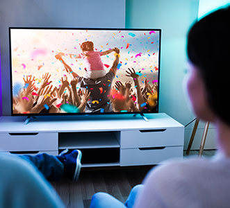 Happy couple watching TV at home - covered by Smart Cover Infotainment Insurance